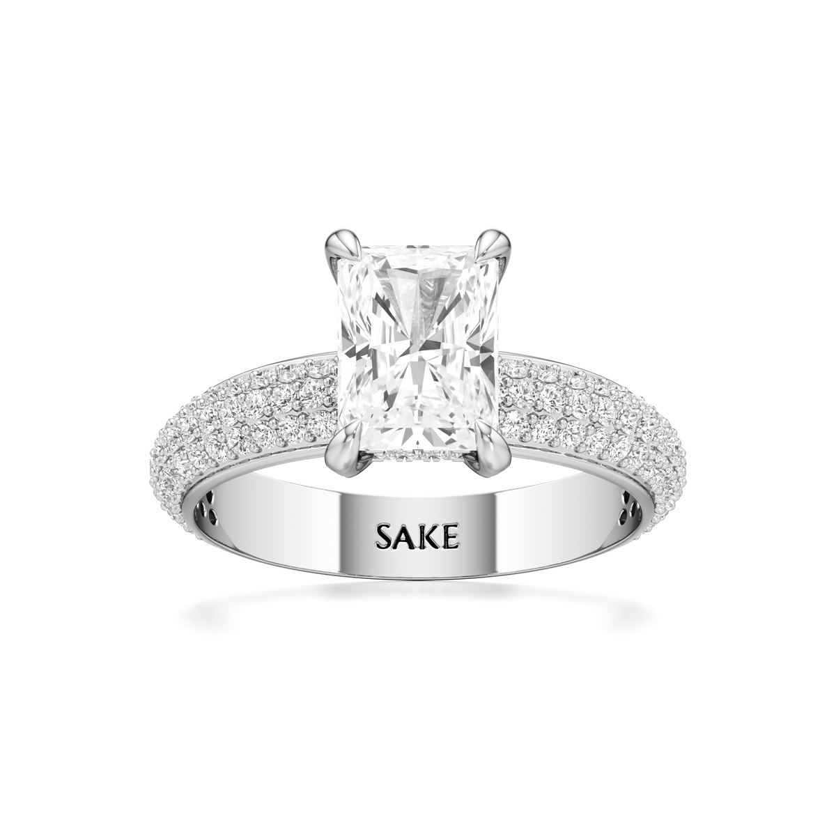 A silver-toned diamond engagement ring featuring a rectangular princess-cut center stone and pavé-set diamonds on the band, with the brand name 'SAKE' engraved inside the band, shown on a white background.
