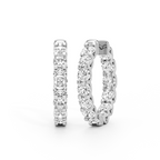 A pair of silver-toned huggie hoop earrings set with round-cut clear gemstones, shown from the front and side on a clean white background.