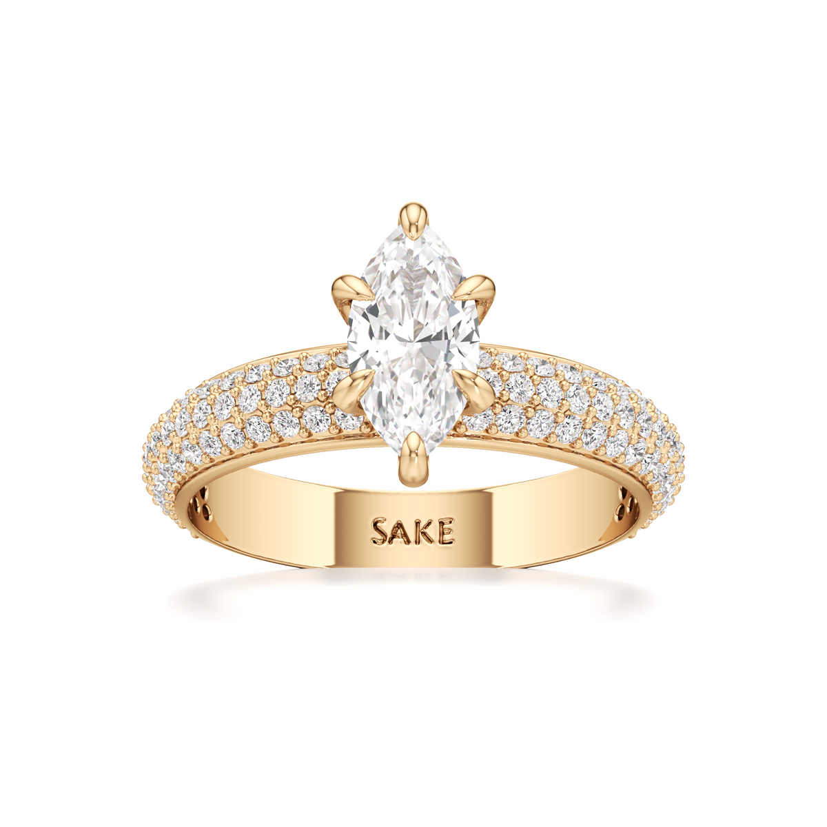 A yellow gold ring featuring a large oval-cut center stone and a pavé-set band with small clear stones. The inside of the band is engraved with the brand name 'SAKE'.
