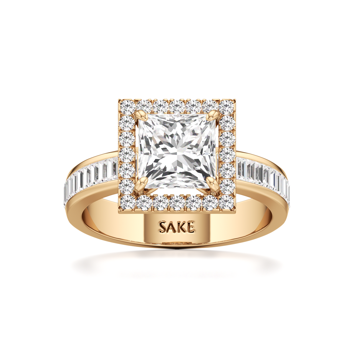 A yellow gold ring with a princess-cut diamond center stone and a halo of smaller diamonds, featuring a band with baguette and round diamonds. The inside of the band is engraved with the brand name 'SAKE'.