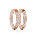 Pair of rose-gold oval pavé hoop earrings displayed at an angle to show their shape and stone detailing.