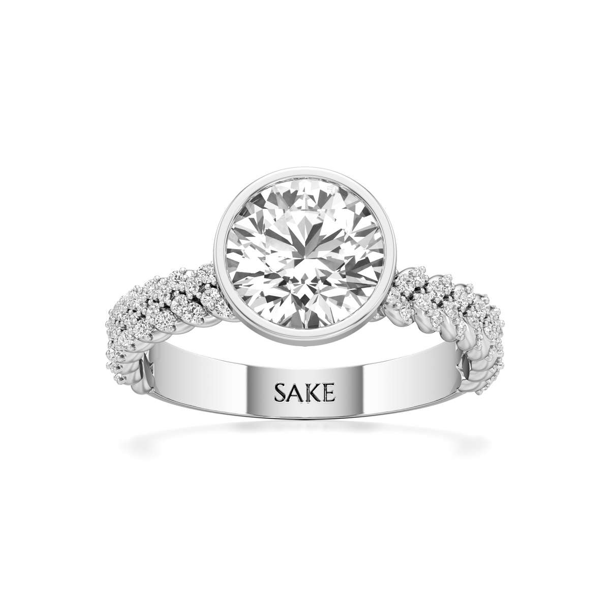 A silver-toned diamond ring with a large round center stone and a pavé band engraved with the name 'SAKE', shown on a clean white background.