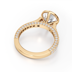 A yellow gold ring with a large marquise-cut clear center stone and a halo setting, featuring a pavé band with small round stones, shown on a white background.