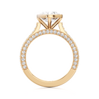 A yellow gold ring with a large round-cut center stone and a pavé-set band of small clear stones, shown on a plain white background.