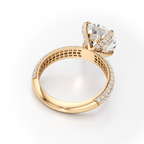 A yellow gold ring with a large round-cut clear gemstone in a halo setting, accented by small pavé diamonds along the band, shown on a clean white background.