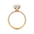A yellow gold ring featuring a large heart-shaped clear gemstone in a prong setting, with a pavé band adorned with small round diamonds, shown on a plain white background.