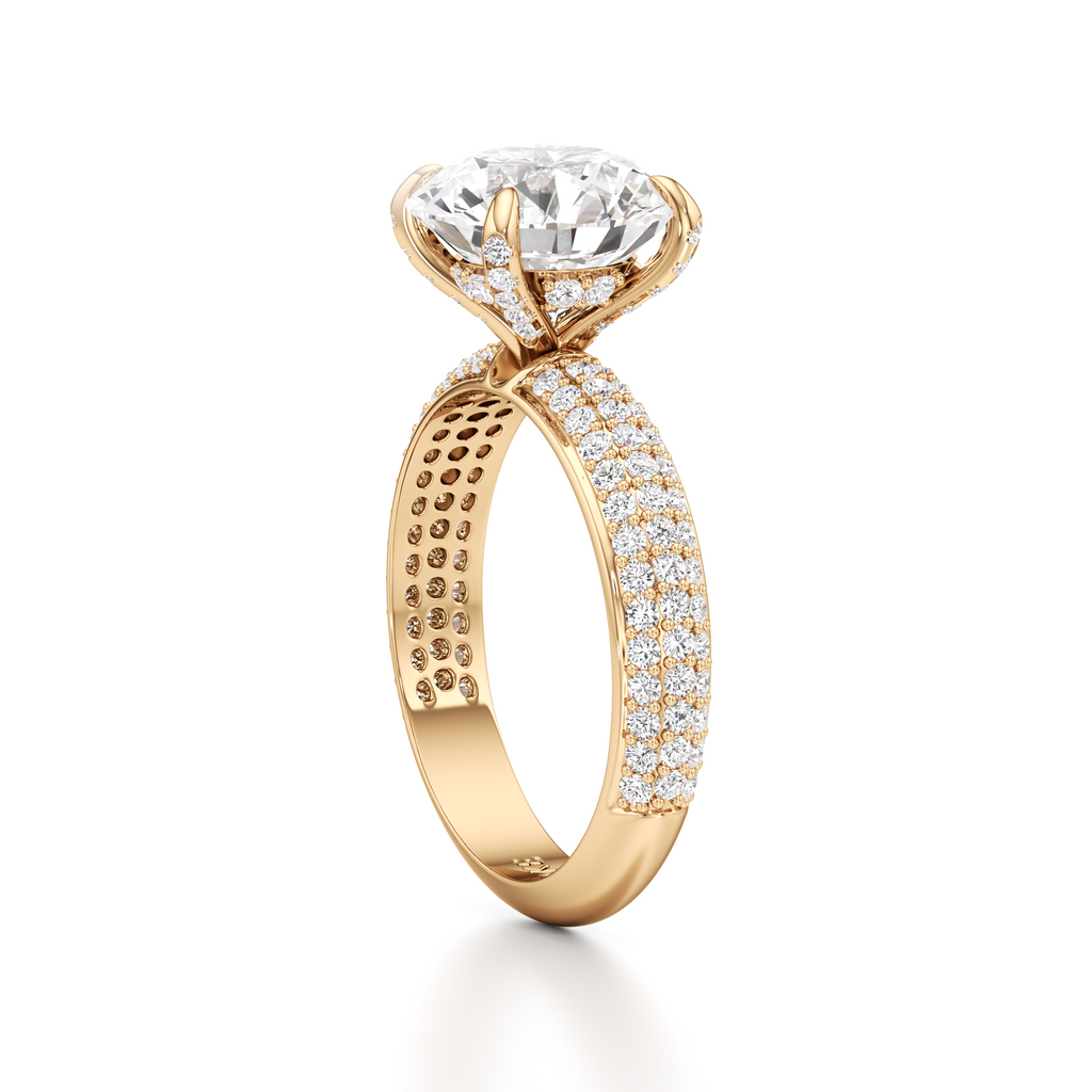 A yellow gold diamond ring with a large round-cut center stone and pavé-set diamonds along the band, shown on a clean white background.
