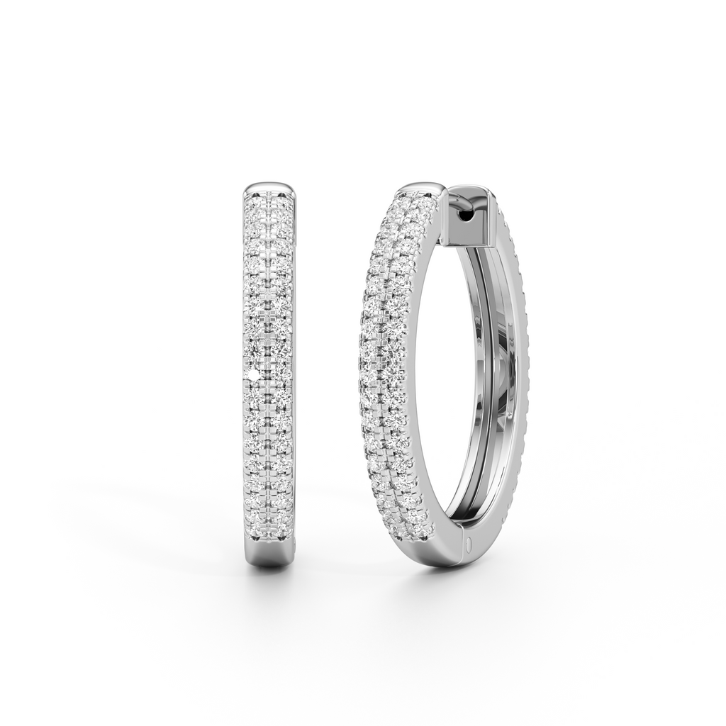 A pair of silver huggie hoop earrings paved with small clear stones, shown from the front and side on a clean white background.