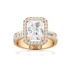 A yellow gold ring with a large rectangular emerald-cut center stone surrounded by a halo of small clear stones, and a channel-set stone band, shown on a white background. The inside of the band is stamped with 'SAKE'.