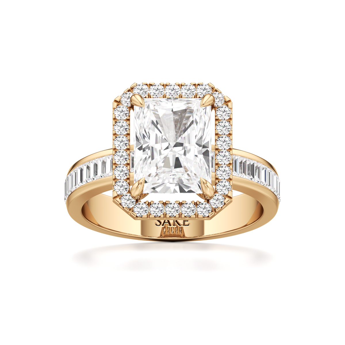 A yellow gold ring with a large rectangular emerald-cut center stone surrounded by a halo of small clear stones, and a channel-set stone band, shown on a white background. The inside of the band is stamped with 'SAKE'.