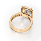 A yellow gold ring with a square bezel setting holding a large clear princess-cut center stone, accented with small side stones, shown on a clean white background.