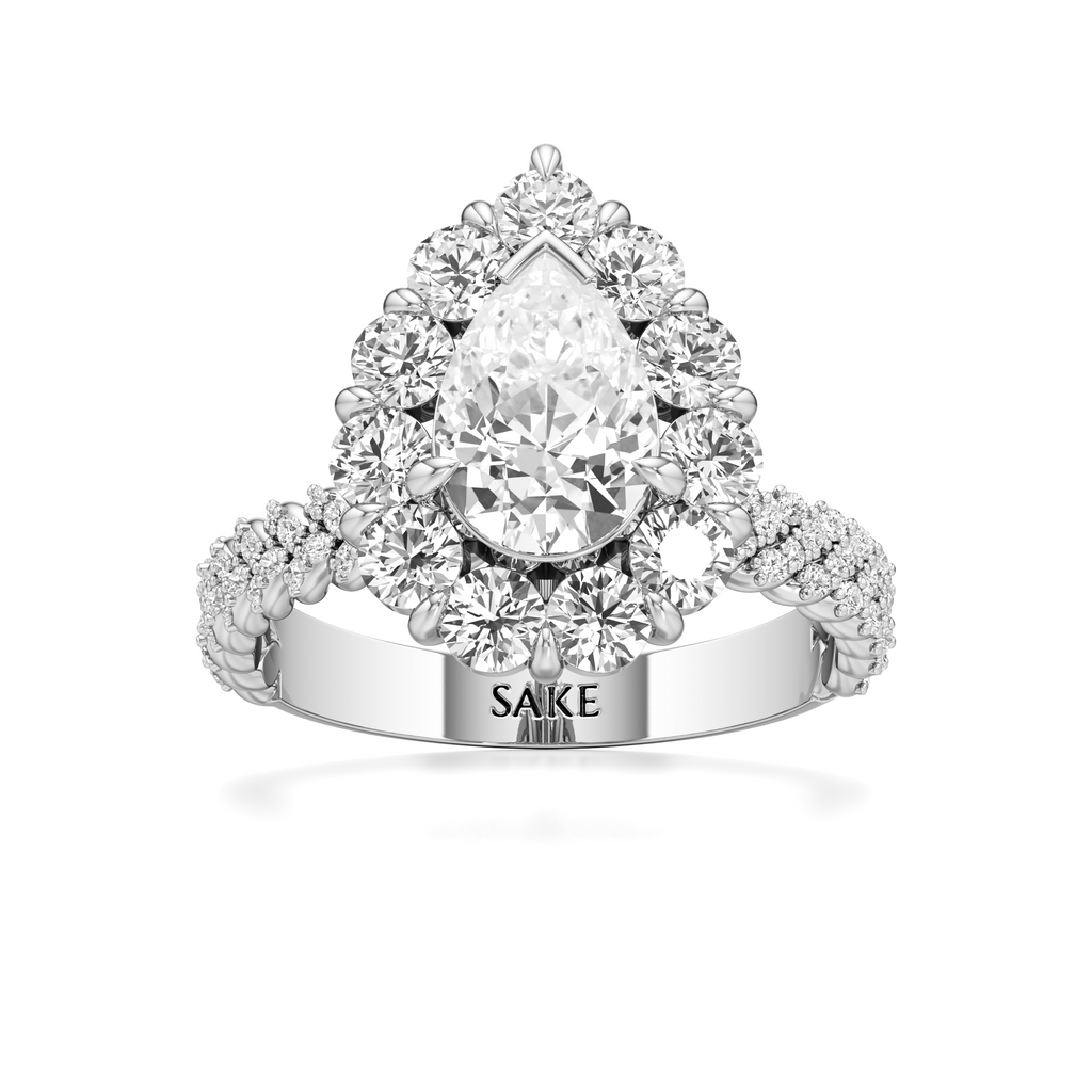 A pear-cut diamond halo ring in white gold or platinum, featuring a large central pear diamond surrounded by round and marquise diamonds, with a split shank engraved with 'SAKE ADAM'.