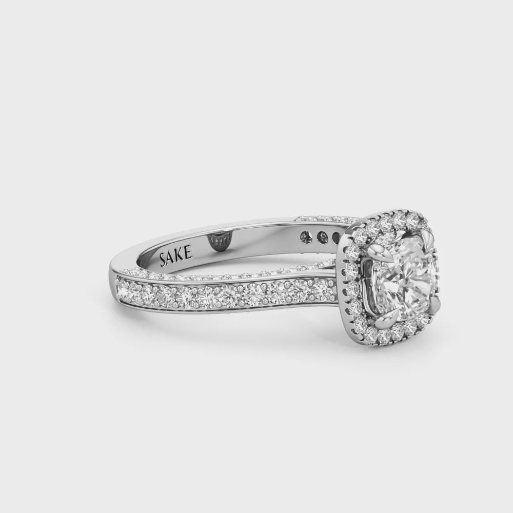 Silver-toned halo diamond ring with a pavé-set band and a cushion-shaped halo surrounding the center stone.